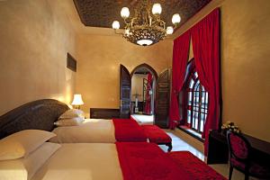 1 dormitorio con cama y lámpara de araña en Palais Shéhérazade & Spa, en Fez
