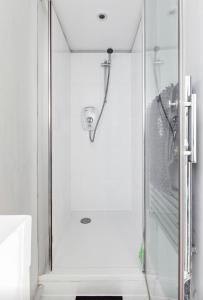 La salle de bains est pourvue d'une douche avec une porte en verre. dans l'établissement Studio, Private, independant Entrance, Central, Battersea Park, à Londres