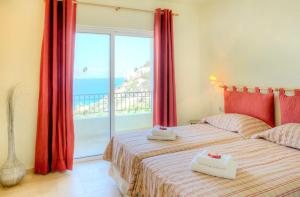 1 dormitorio con 2 camas y ventana grande en Istron Collection Villas, en Istron