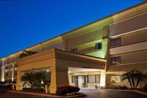 a large building with palm trees in front of it at La Quinta by Wyndham Tampa Fairgrounds - Casino in Tampa