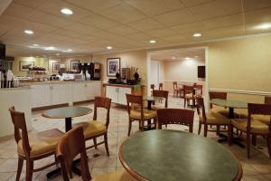 a restaurant with tables and chairs and a kitchen at La Quinta by Wyndham Tampa Fairgrounds - Casino in Tampa