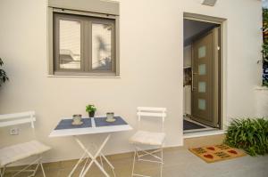 a table and two chairs in a room with a window at Antigonis Garden House in Chania