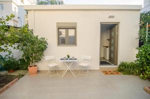 a patio with a table and chairs in front of a house at Antigonis Garden House in Chania