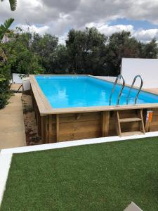 a swimming pool with a wooden deck and a blue pool at Quinta da Paz B&B in Portimão