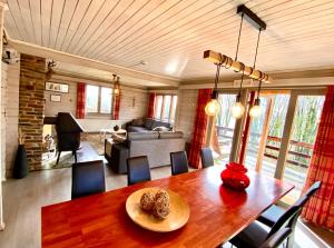 a dining room with a table and a living room at Chalet de Charme in Rochehaut