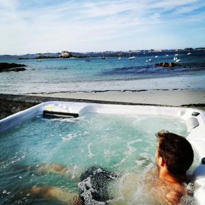 Ein Mann in einer Badewanne am Strand. in der Unterkunft Le Prat - Santec in Santec