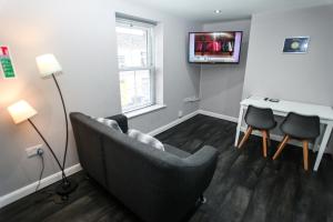 a living room with a couch and a table and a tv at No 4 New Inn Apartments in Newark-on-Trent