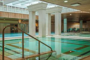 een zwembad in een gebouw met een plafond bij The Aquincum Hotel Budapest in Boedapest
