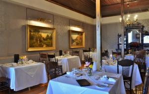 a dining room with tables with white tablecloths at Swartberg Hotel, Cork Tree Collection in Prince Albert