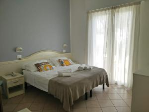 a bedroom with a bed with towels on it at Hotel Garnì Anna in Cervia
