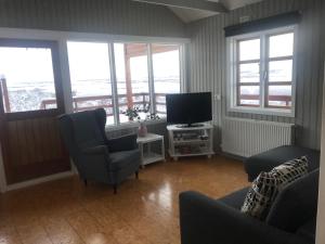 a living room with two chairs and a television at Sólbakki Holiday Home in Egilsstaðir