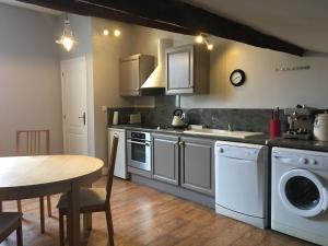 a kitchen with a table and a sink and a dishwasher at Apart d'Arc in Saintes