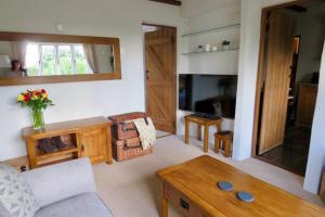 a living room with a couch and a table at Wolfin Farm Accomodation in Crediton