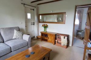 een woonkamer met een bank en een tafel bij Wolfin Farm Accomodation in Crediton
