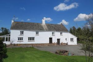 a large white house with a grassy yard at Wolfin Farm Accomodation in Crediton