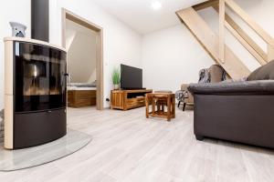 a living room with a tv and two couches at NESS by Mountain ways in Boží Dar