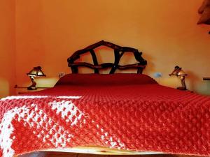 1 dormitorio con 1 cama roja y 2 lámparas. en Cabañas Calderón II en San Rafael