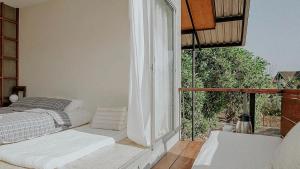 a bedroom with a bed and a large window at Baan Lek Villa in Chanthaburi