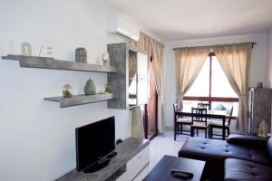 モロ・デル・ハブレにあるVIP HOLIDAYS Morro Jable Beach & Center 2のソファと薄型テレビのあるリビングルーム