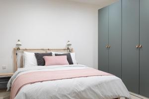 a bedroom with a bed with a pink pillow at Cosy apartment in Historic Fort Chambray, Gozo in Mġarr