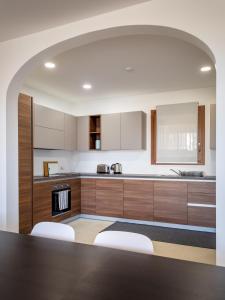 a kitchen with a table and some white cabinets at Cosy apartment in Historic Fort Chambray, Gozo in Mġarr