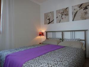 a bedroom with a large bed with a purple blanket at Apartment mit Traumblick in Sóller