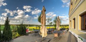 a patio with tables and umbrellas and a view at Penzion Blanský Les in Dubné