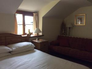 sypialnia z łóżkiem, kanapą i oknem w obiekcie TAN Y GRAIG w mieście Meifod