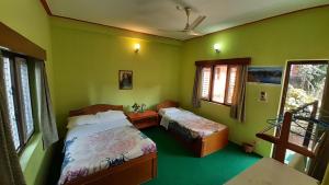 A bed or beds in a room at New Pokhara Lodge - Pokhara Lakeside