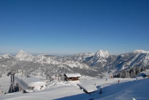 einen schneebedeckten Berg mit Menschen an einer Skipiste in der Unterkunft Haus Pfauth in Tannheim