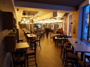 a restaurant with tables and chairs and a person walking in a room at Milmari RELAX apartment in Kopaonik