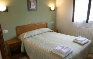 1 dormitorio con 1 cama con 2 toallas en Apartamentos Rurales La Granda, en Cangas de Onís