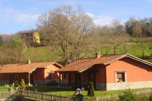 a house in a yard with a fence at Apartamentos Rurales La Granda in Cangas de Onís