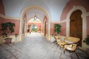 un pasillo vacío con sillas y una mesa en un edificio en Palazzo Laura, en Morciano di Leuca
