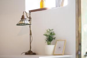 een lamp op een plank naast een plant bij Ablak a hegyre vendégház in Mindszentkálla