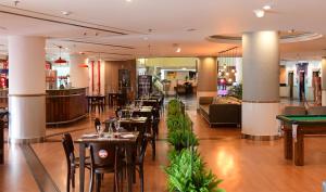 a restaurant with tables and chairs and a pool table at Pestana São Paulo in Sao Paulo