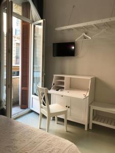 1 dormitorio con escritorio, silla y ventana en AZUR HOTEL en Beausoleil