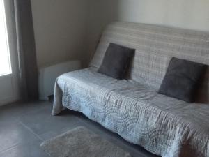 a bed with two pillows on it in a room at Logement avec magnifique vue des montagnes in Digne-les-Bains