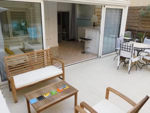 eine abgeschirmte Veranda mit einer Bank und einem Tisch in der Unterkunft Lovely 1 Bedroom Boulevard de la Croisette in Cannes