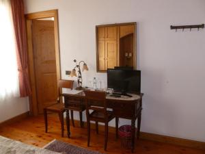 um quarto com uma secretária, uma televisão e uma mesa em Cadore Haus em Auronzo di Cadore