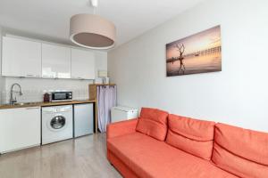 ein Wohnzimmer mit einem Sofa und einer Küche in der Unterkunft Modern and bright flat in Monplaisir district Lyon center - Welkeys in Lyon