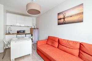 ein Wohnzimmer mit einem roten Sofa und einer Küche in der Unterkunft Modern and bright flat in Monplaisir district Lyon center - Welkeys in Lyon