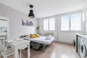 uma sala de estar branca com uma mesa e uma cozinha em Nice and modern studio in Monplaisir district in Lyon - Welkeys em Lyon