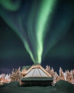 an igloo with the aurora in the sky at Northern Lights Village Levi in Levi