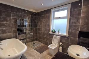 ein Badezimmer mit Badewanne, Waschbecken und Toilette in der Unterkunft Broomfield Cottage South Luss in Glasgow + 14 Fotos