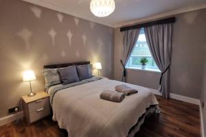 ein Schlafzimmer mit einem Bett mit zwei Handtüchern darauf in der Unterkunft Broomfield Cottage South Luss in Glasgow