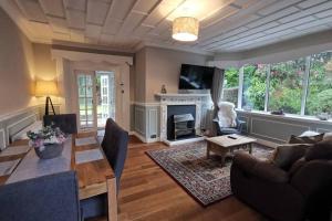 ein Wohnzimmer mit Couch und Kamin in der Unterkunft Broomfield Cottage South Luss in Glasgow