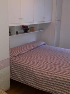 uma cama num quarto com armários brancos em Le betulle - 022147-AT-050930 em Predazzo