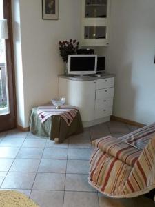 - un salon avec une télévision et une table dans l'établissement Le betulle - 022147-AT-050930, à Predazzo