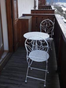 - deux chaises et une table sur une terrasse couverte dans l'établissement Le betulle - 022147-AT-050930, à Predazzo